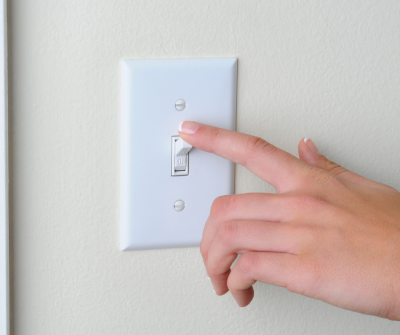 hand turning on light switch